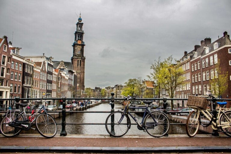 Kanał w Amsterdamie z rowerami zaparkowanymi na moście
